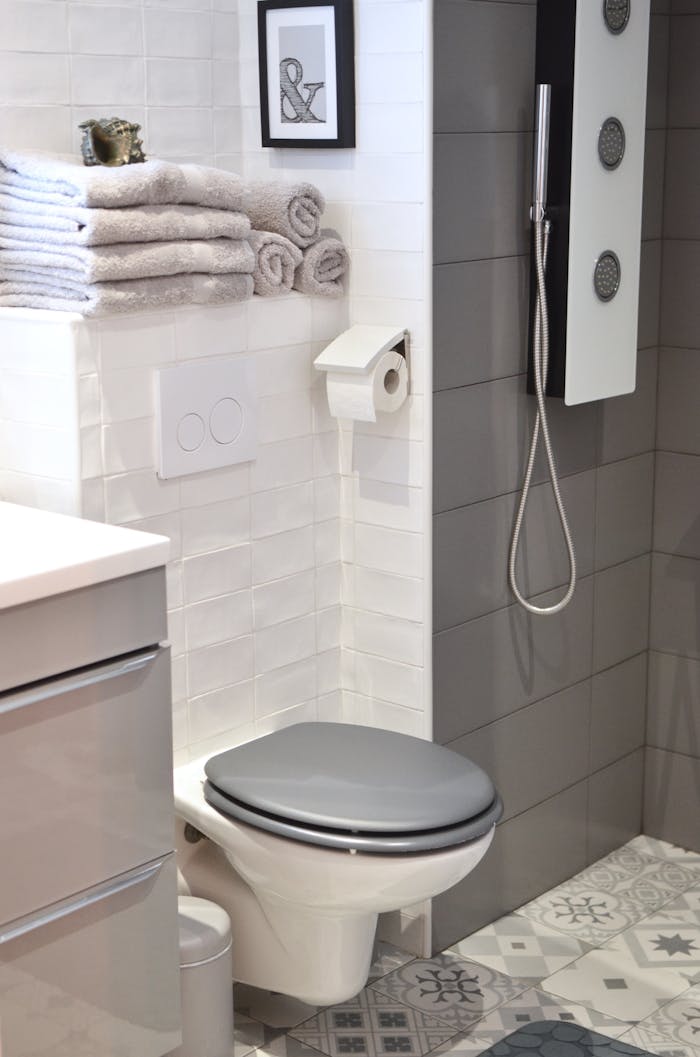 Elegant modern bathroom with tiled walls, shower, and compact toilet.