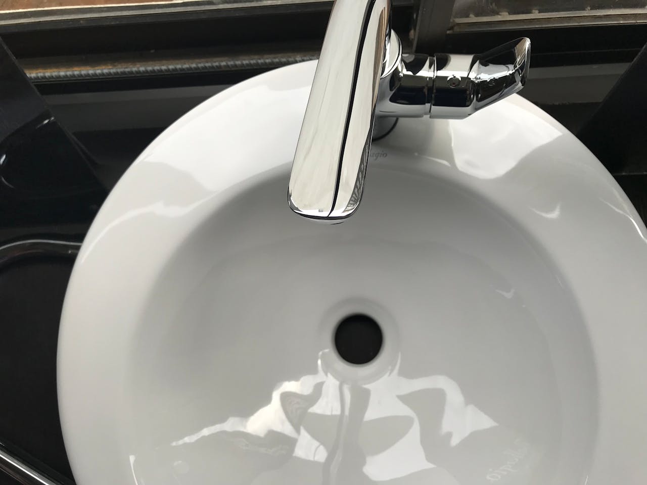 Close-up image of a modern stainless steel faucet and ceramic sink, highlighting cleanliness and hygiene.